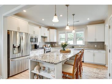 Bright kitchen features stainless steel appliances, granite counters, and a large center island with pendant lighting at 4511 Middlebury Ln, Fort Mill, SC 29715