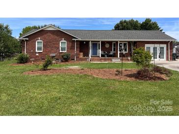 Charming brick home featuring a manicured front yard, covered porch, and inviting curb appeal at 4527 Marshall Ct, Monroe, NC 28110