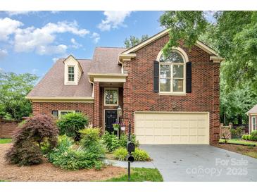 Charming brick home featuring a manicured lawn, two-car garage, and inviting front entrance at 7031 Walton Heath Ln, Charlotte, NC 28277