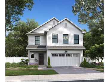 Charming two-story home with white siding, black windows, and attached two car garage at 733 Oak St, Charlotte, NC 28214
