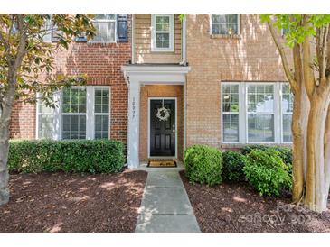 Charming brick home with a welcoming black front door and manicured landscaping at 10027 Juniper Trace Dr, Charlotte, NC 28277