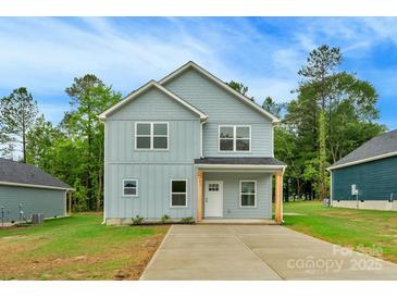 Charming two-story home with light blue siding, a cozy front porch, and a well-manicured lawn at 103 Churchill Dr, Kings Mountain, NC 28086