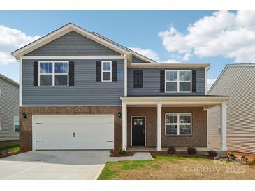 Two-story home with a brick and blue facade, attached garage, and a covered front porch at 11131 Cardinal Creek Ave, Charlotte, NC 28215