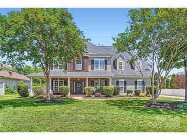 Charming two-story home with mature trees, manicured lawn, brick accents, and a welcoming front porch at 113 Dairy Farm Rd, Mooresville, NC 28115