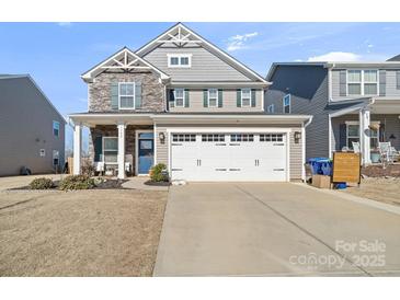 Charming two-story home featuring a stone facade, gray siding, and a two-car garage at 1708 Speartip Ln, Denver, NC 28037