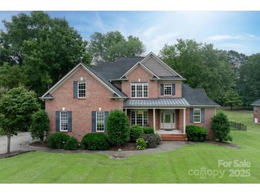 Elegant two-story brick home with a lush green lawn and manicured landscaping at 1912 Windmere Dr, Monroe, NC 28110