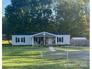 Charming home featuring a cozy front porch, well-maintained lawn, and a convenient storage shed in the backyard at 2291 Howell Rd, Midland, NC 28107