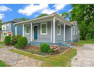Charming home with a welcoming front porch, complemented by colorful landscaping and a stone walkway at 3400 Reid Ave, Charlotte, NC 28208