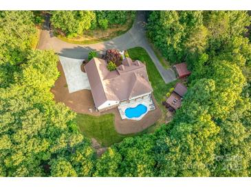 Stunning aerial view of estate home with in-ground pool, sprawling lawn, and mature trees at 560 Blue Sky Dr, Dallas, NC 28034