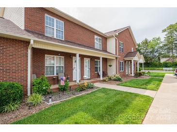 Attractive brick townhouse featuring well-maintained landscaping, a covered porch, and welcoming curb appeal at 102 Brandywine Ne Dr # O-3, Conover, NC 28613