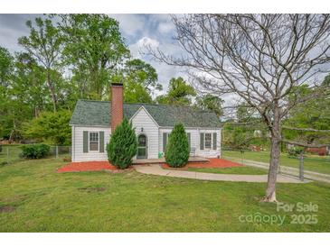 Charming home with a brick chimney, green roof, and a well-manicured front yard at 123 N Poston St, Shelby, NC 28150