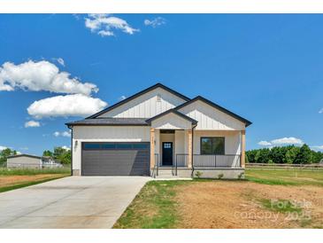 Charming home featuring a modern farmhouse exterior, covered porch, and an attached two-car garage at 2104 County Line Rd, Kings Mountain, NC 28086