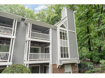 Charming condo featuring balconies and large windows, nestled among lush green trees, offering serene living at 2512 Cranbrook Ln # 9, Charlotte, NC 28207