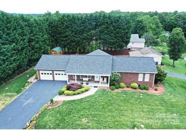 Charming brick home with attached two-car garage, well-manicured lawn, and mature trees at 4646 River Run Cir, Hickory, NC 28602