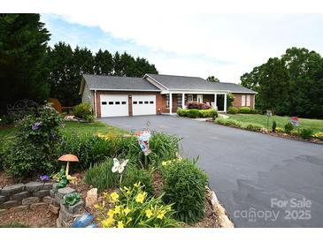 Charming brick home featuring a two-car garage, landscaped front yard, and inviting front porch at 4646 River Run Cir, Hickory, NC 28602