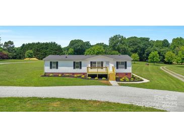 Charming single-story home featuring fresh exterior paint, and a cute wooden deck at 5606 S Rocky River Rd, Monroe, NC 28112