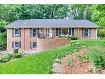 Charming brick home featuring a well-manicured lawn and inviting front entrance at 6626 Rocky Falls Rd, Charlotte, NC 28211