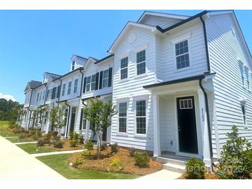 Charming row of white townhouses with black accents, well-manicured lawns, and inviting curb appeal at 8102 Jacey Ln # 24, Huntersville, NC 28078