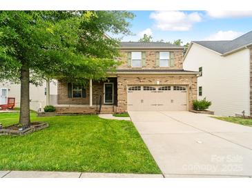 Charming two-story brick home with a covered front porch and attached two-car garage at 12923 Plumleaf Dr, Charlotte, NC 28213
