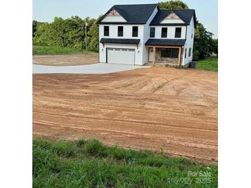 Charming two-story home with black roof, white siding, and attached garage at 1308 Austin Chaney Rd, Wingate, NC 28174