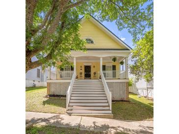 Charming yellow two-story home featuring a welcoming front porch and well-maintained yard at 14105 Garden District Row, Huntersville, NC 28078