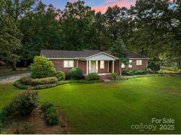 Charming brick home with a well-maintained front lawn and mature trees at 14415 Old Beatty Ford Rd, Gold Hill, NC 28071