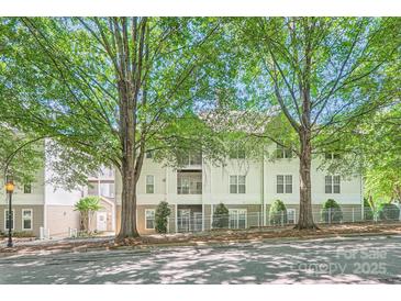 Apartment building exterior showcasing balconies and trees providing shade on a sunny day at 18605 Ruffner Dr # 3E, Cornelius, NC 28031