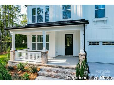 Charming front porch with brick accents, white columns, and a cozy seating area at 236 Wheatfield Dr # 102P, Statesville, NC 28677