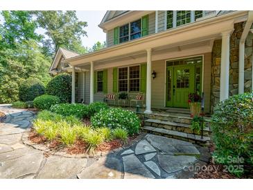 Charming front porch with stone accents, vibrant green door and shutters, and inviting landscape at 258 Patterson'S Bridge None, New London, NC 28127