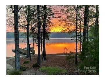 Scenic waterfront view at sunset with a private dock and tranquil lake reflecting the warm colors at 258 Patterson'S Bridge None, New London, NC 28127