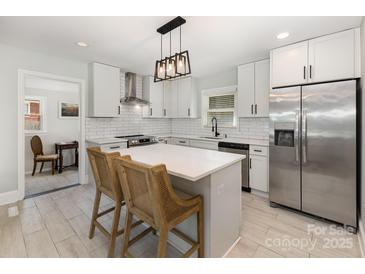Bright white kitchen featuring stainless steel appliances, a center island, and shaker cabinets at 3615 Kempton Pl, Charlotte, NC 28208
