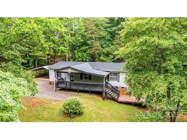 Charming single-story home with a metal roof, front deck, and wooded surroundings at 51 Emily Ln, Taylorsville, NC 28681