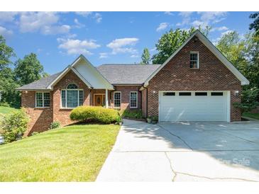 Charming two-story brick home with a well-manicured lawn and a spacious driveway leading to a two-car garage at 7545 Rabbit Cir, Denver, NC 28037