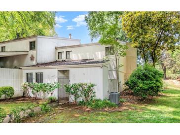 Charming white two-story home with a manicured lawn and lush landscaping at 7900 Horse Chestnut Ln, Charlotte, NC 28277