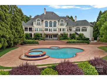 Beautiful backyard pool and spa with brick surround and lush landscaping, perfect for entertaining at 8800 Covey Rise Ct, Charlotte, NC 28226