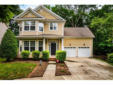 Charming two-story home with a manicured lawn and a two-car garage with mature landscaping at 9410 Greenbank Ct, Charlotte, NC 28214