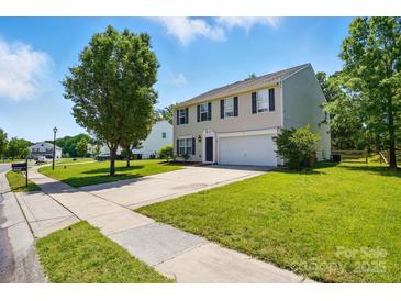 Charming two-story home with a well-maintained lawn and a paved driveway leading to an attached two-car garage at 1005 Exodus Ct, Monroe, NC 28110