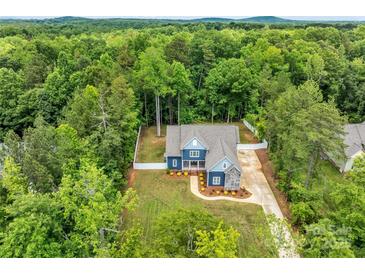 Stunning aerial view of a blue two-story home nestled in a lush green forest at 1622 Hunters Place Rd, York, SC 29745