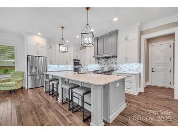 Bright kitchen with large island, stainless steel appliances, and hardwood flooring at 1622 Hunters Place Rd, York, SC 29745