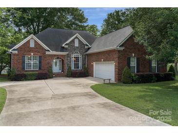 Charming brick home with manicured lawn, arched entryway, and a spacious driveway to a two car garage at 18118 Pompano Pl, Cornelius, NC 28031