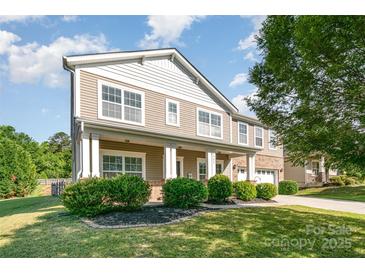 Charming two-story home featuring a welcoming porch, manicured lawn, and tasteful landscaping at 1905 Yellow Daisy Dr, Matthews, NC 28104