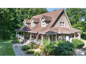 Charming two-story home featuring a welcoming front porch, American flag, and beautifully landscaped yard at 2168 Sunset Cir, Fort Mill, SC 29715