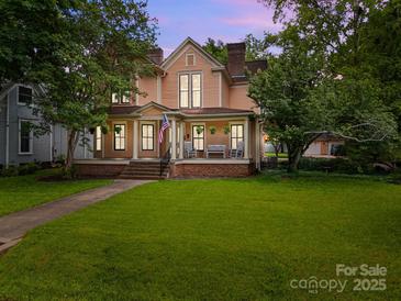 Charming two-story home with a welcoming front porch and lush green lawn at 217 S Ellis St, Salisbury, NC 28144