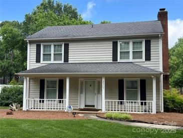 Charming two-story home featuring a welcoming front porch, black shutters, and a well-maintained lawn at 2507 Birnen Dr, Charlotte, NC 28210