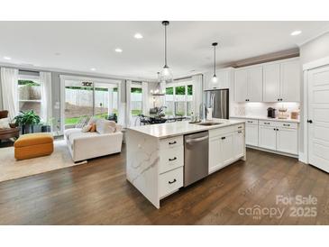 Modern kitchen with a large waterfall island, stainless steel appliances, and an open floor plan concept at 2517 Marlowe Ave, Charlotte, NC 28208