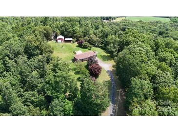 Expansive aerial view showcasing a home with a barn and long driveway nestled among lush greenery and mature trees at 3151 Lynn Mountain Rd, Vale, NC 28168