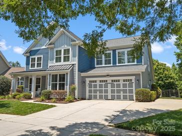 Charming two-story home with a manicured lawn, two-car garage, and a welcoming blue and gray color scheme at 5005 Hedgebrook Ln, Waxhaw, NC 28173