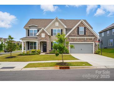 Charming two-story home featuring stone accents, a gray two-car garage, and a manicured front lawn at 5114 Whispy Vines Ln, Huntersville, NC 28078