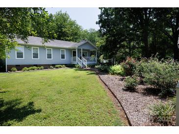 Charming home with a well-maintained front lawn, complemented by beautiful flowerbeds and mature trees at 517 Powell St, Rock Hill, SC 29732