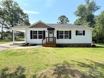 Charming single-story home featuring a well-maintained front lawn, covered carport, and classic black shutters at 111 W Perry St, Heath Springs, SC 29058